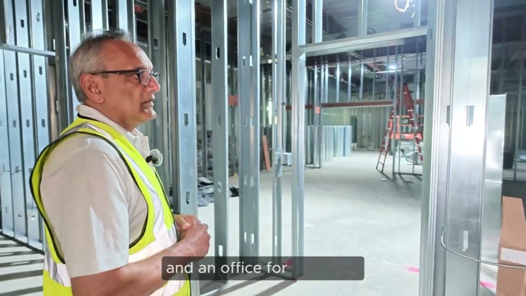 President Rahmat Awan walking through the framed-out Phase-4 construction in a high-visibility vest